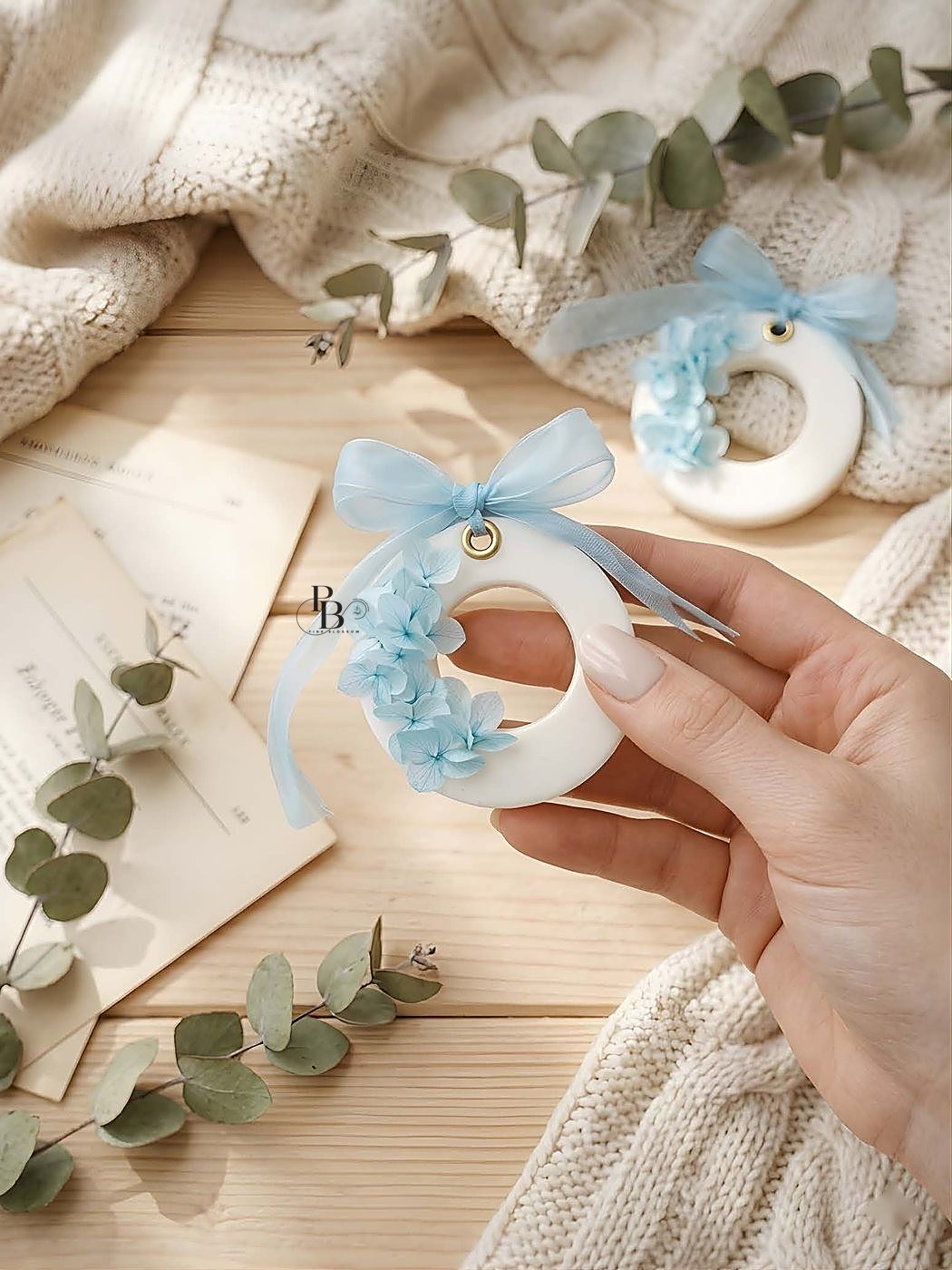 Hand holding a ring-shaped wax sachet with blue flowers and ribbon, handmade soy wax, Pink Blossom bulk order