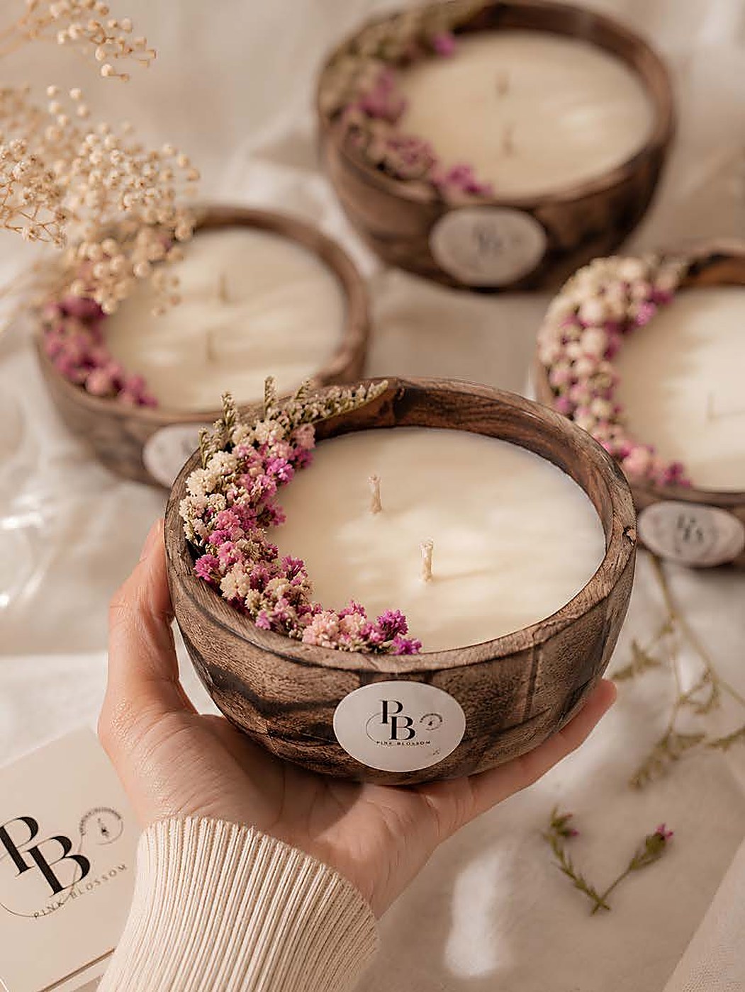 Hand holding a wooden bowl candle edged with dried flowers, Wooden Bowl (3.5 Inches), handmade soy wax, Pink Blossom bulk order